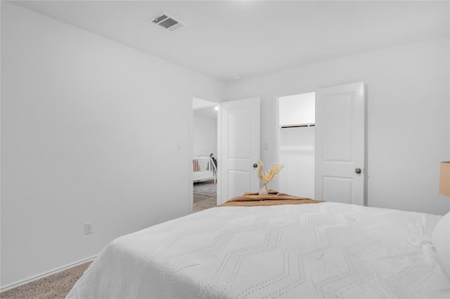 carpeted bedroom featuring visible vents