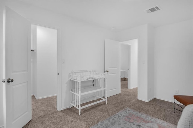 carpeted bedroom with visible vents and baseboards