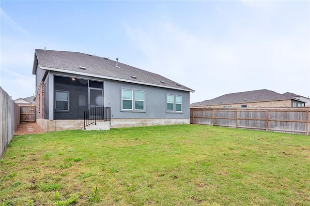 back of house featuring a yard and a fenced backyard