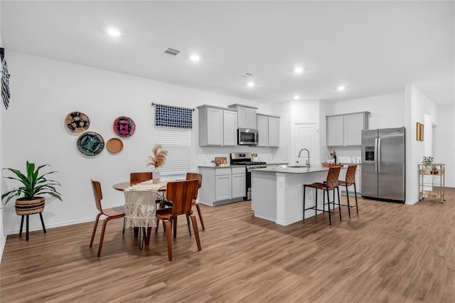 kitchen featuring visible vents, gray cabinets, stainless steel appliances, and light wood-style flooring