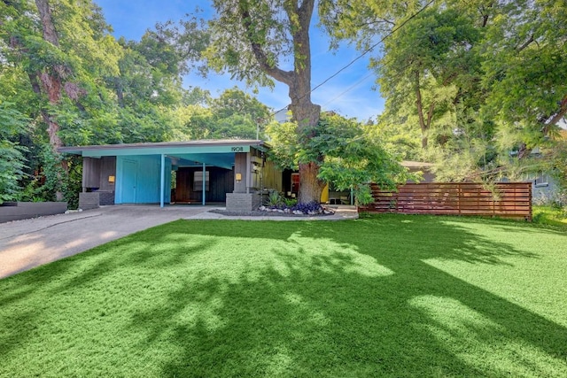 rear view of property with driveway, a lawn, and a carport