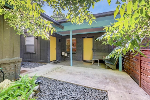 doorway to property with a patio and brick siding