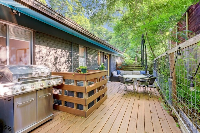 wooden terrace with outdoor dining area and area for grilling