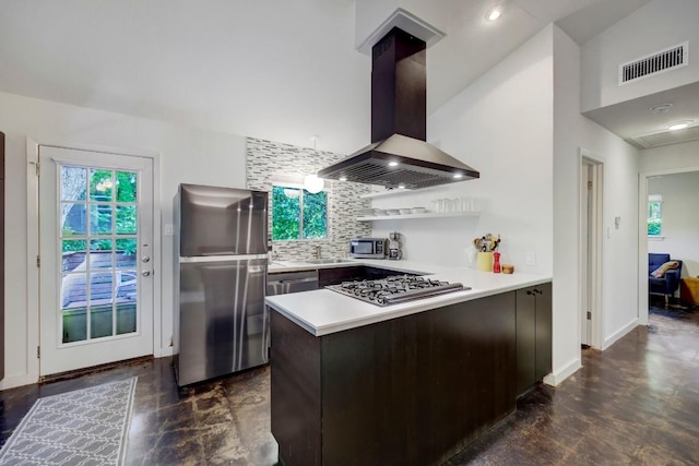 kitchen featuring visible vents, island exhaust hood, backsplash, appliances with stainless steel finishes, and a peninsula