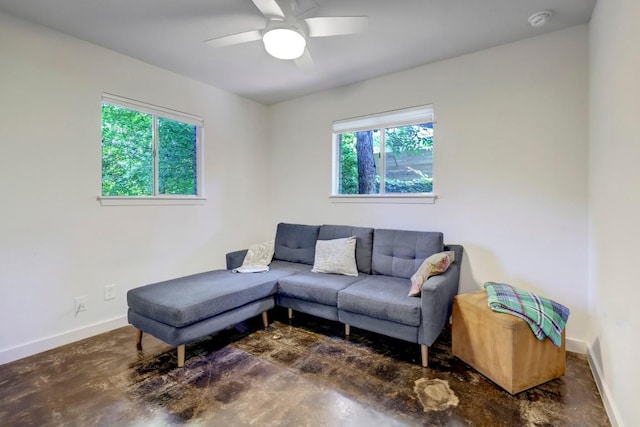 living room with ceiling fan, concrete floors, and baseboards