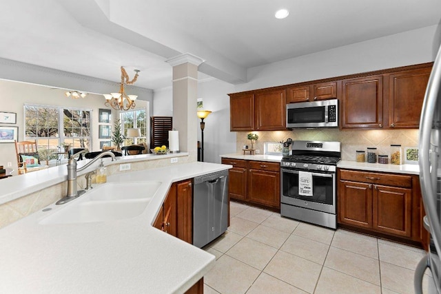 kitchen featuring backsplash, appliances with stainless steel finishes, light countertops, and a sink