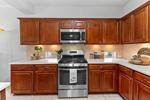 kitchen with light countertops, light tile patterned floors, tasteful backsplash, and stainless steel appliances