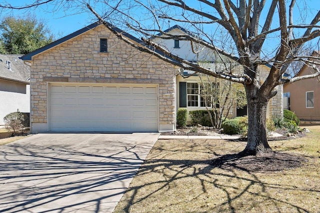 view of front of property featuring an attached garage, stone siding, and driveway