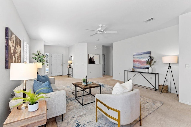 living room featuring light carpet, visible vents, baseboards, and ceiling fan