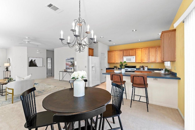 dining space featuring recessed lighting, visible vents, ceiling fan with notable chandelier, and light carpet