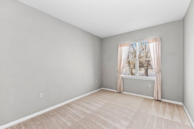 carpeted empty room featuring baseboards