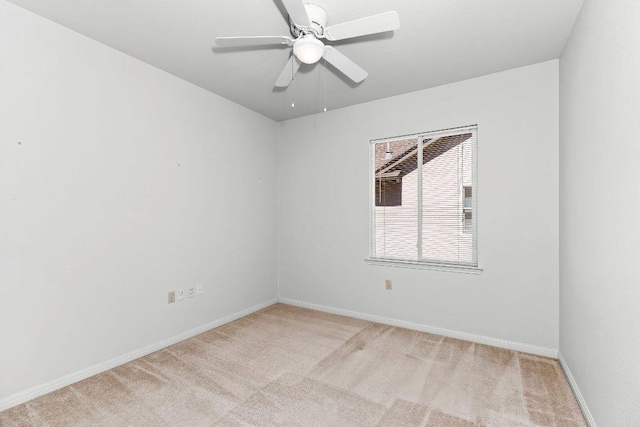 empty room featuring baseboards, light carpet, and a ceiling fan