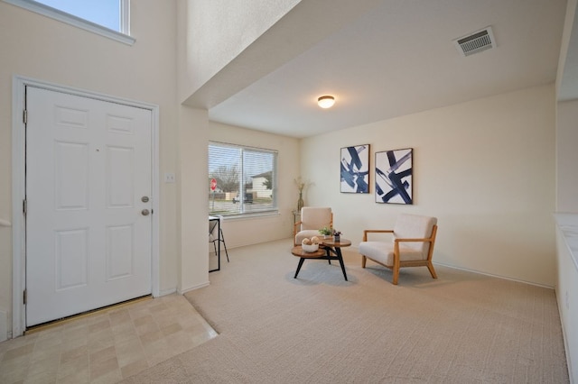 entryway with baseboards, visible vents, and carpet floors