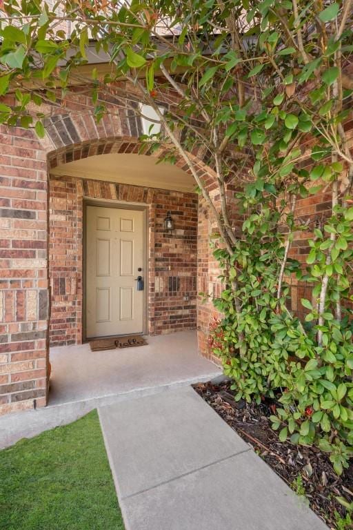 entrance to property featuring brick siding