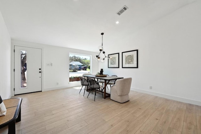 dining area featuring visible vents, light wood-style floors, baseboards, and a chandelier