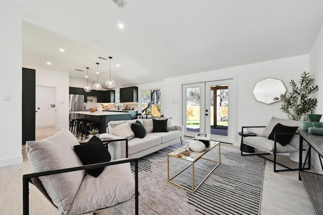 living area featuring recessed lighting, french doors, light wood-type flooring, and baseboards