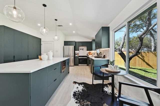 kitchen with visible vents, light wood-type flooring, lofted ceiling, appliances with stainless steel finishes, and tasteful backsplash