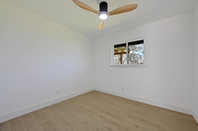 spare room featuring baseboards, light wood-style floors, and a ceiling fan