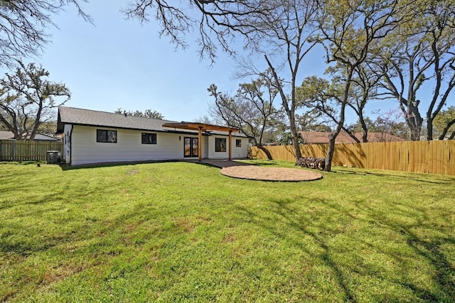 view of front of home featuring cooling unit, a fenced backyard, and a front lawn