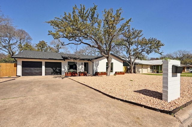 ranch-style house with an attached garage, fence, and driveway