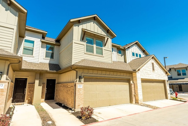 multi unit property featuring brick siding, board and batten siding, concrete driveway, and a shingled roof