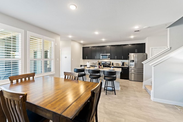 dining area with stairway, recessed lighting, visible vents, and light wood-type flooring