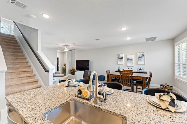 kitchen featuring recessed lighting, a ceiling fan, visible vents, and a sink