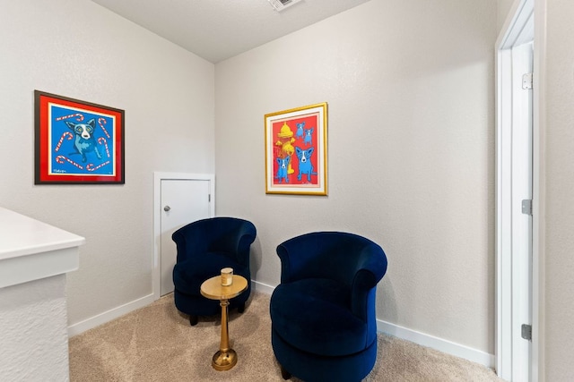 sitting room featuring baseboards and carpet flooring