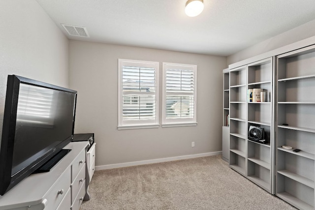 interior space with light carpet, visible vents, and baseboards