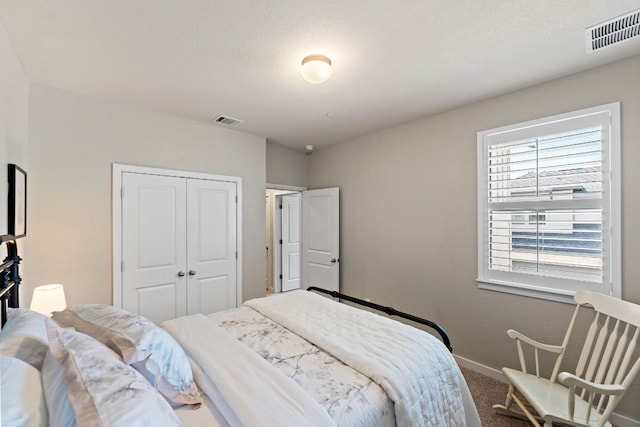 bedroom featuring a closet, visible vents, baseboards, and carpet floors