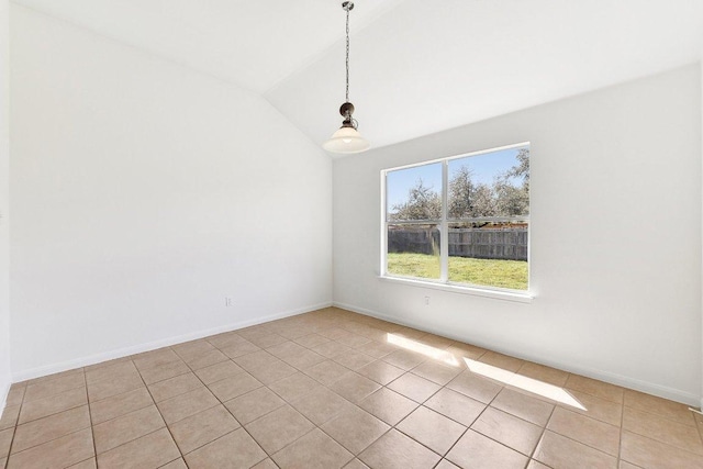 empty room featuring light tile patterned flooring, baseboards, and vaulted ceiling