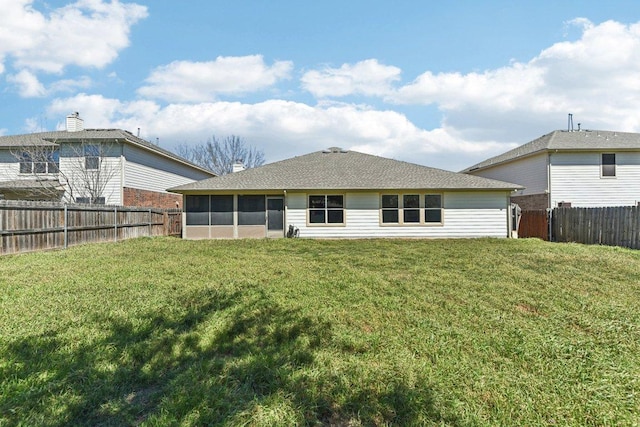 back of house with a sunroom, a lawn, a fenced backyard, and a shingled roof