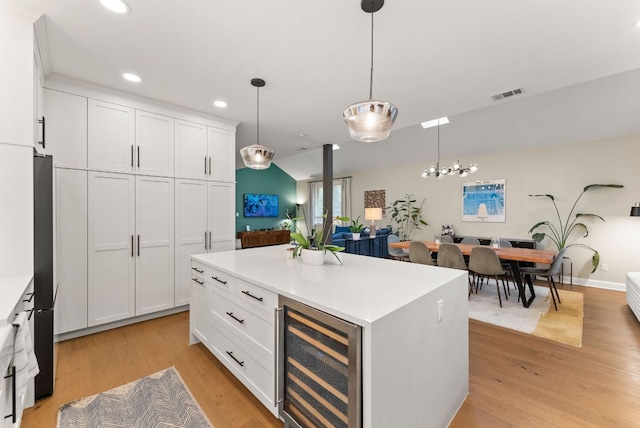 kitchen featuring light wood-type flooring, visible vents, freestanding refrigerator, wine cooler, and white cabinets