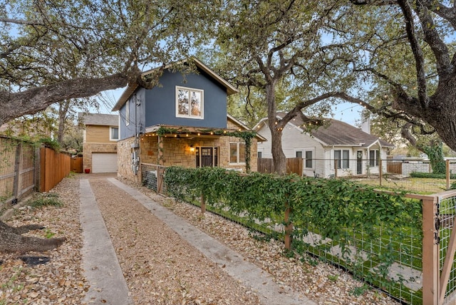 view of front of home with driveway and fence