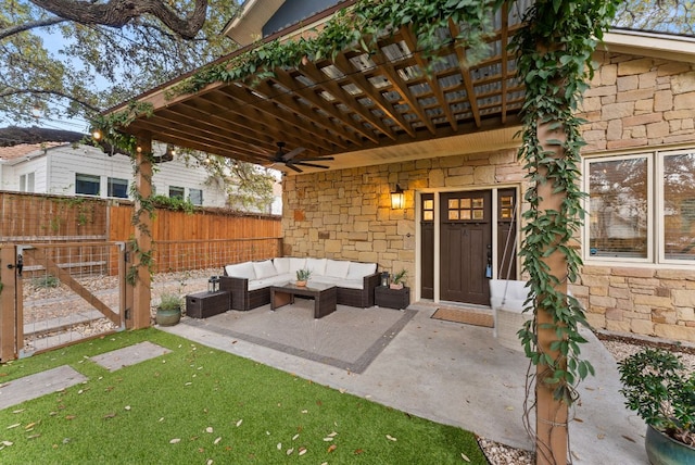 doorway to property with fence, ceiling fan, stone siding, a patio area, and an outdoor hangout area