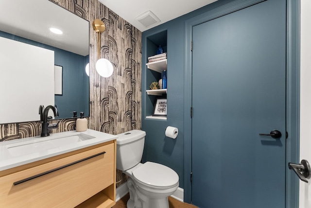 bathroom with visible vents, toilet, and vanity