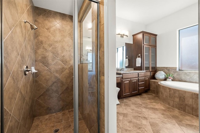 full bathroom with vanity, a shower stall, and a bath