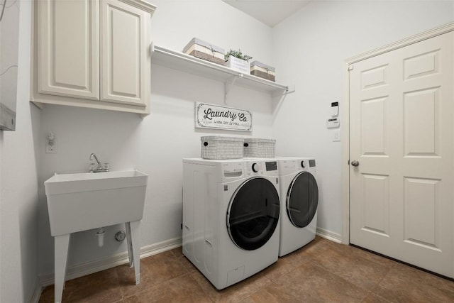 washroom featuring tile patterned floors, washing machine and dryer, cabinet space, and baseboards