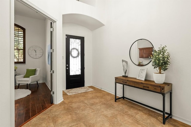 entryway featuring baseboards and arched walkways