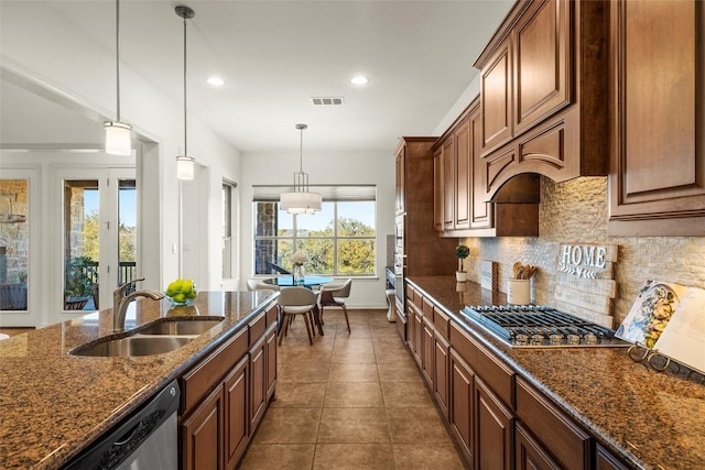 kitchen featuring visible vents, stainless steel appliances, pendant lighting, dark tile patterned floors, and tasteful backsplash