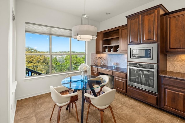 dining space featuring light tile patterned flooring and baseboards