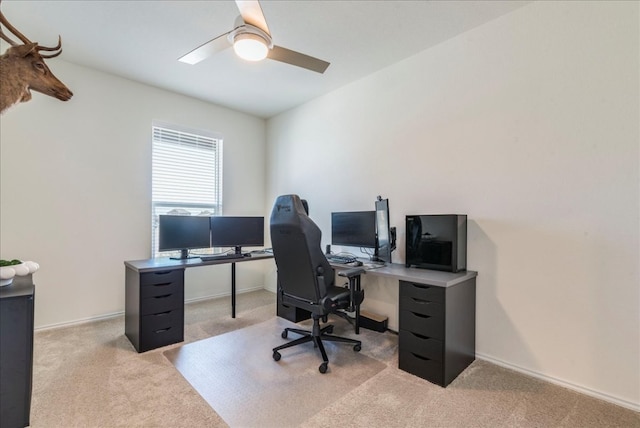 carpeted office featuring baseboards and ceiling fan