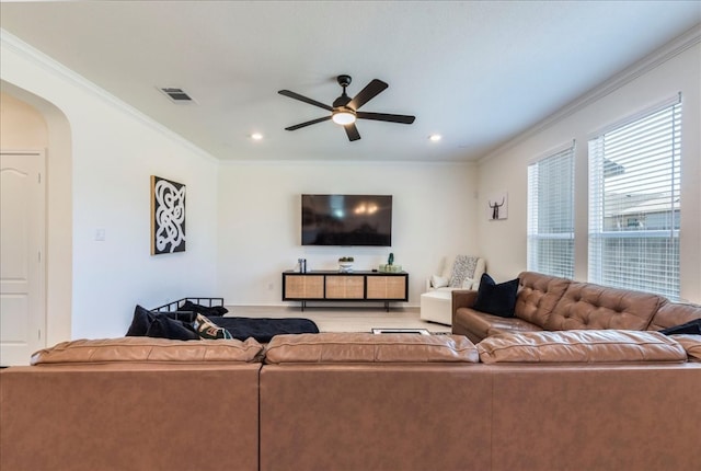 living room featuring arched walkways, visible vents, crown molding, and ceiling fan