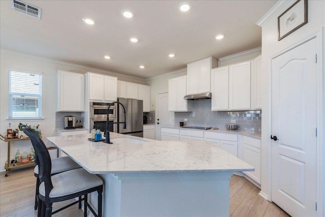 kitchen featuring under cabinet range hood, backsplash, appliances with stainless steel finishes, and ornamental molding