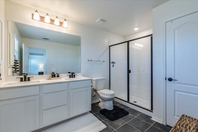 bathroom featuring a sink, double vanity, a stall shower, and tile patterned floors