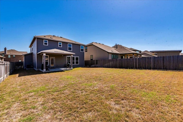 back of house featuring a patio area, a fenced backyard, and a lawn