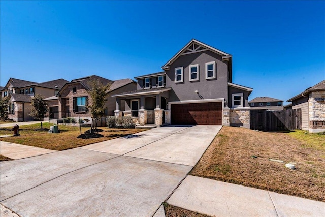 view of front of home featuring a front lawn, a residential view, driveway, stone siding, and an attached garage