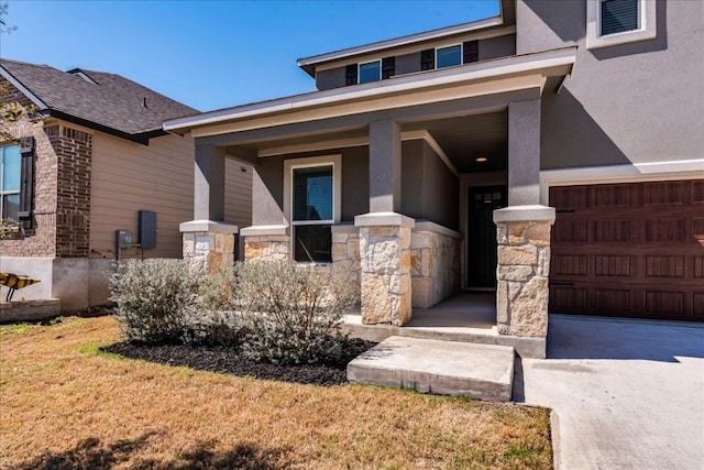 view of exterior entry featuring stucco siding, stone siding, and driveway