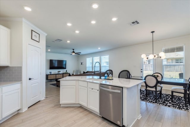 185 Six Shooter Dr, Kyle, TX 78640 - kitchen with stainless steel dishwasher, open floor plan, light wood-style floors, ceiling fan, and ornamental molding