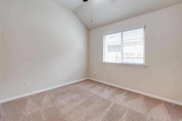 empty room with light colored carpet, baseboards, lofted ceiling, and ceiling fan